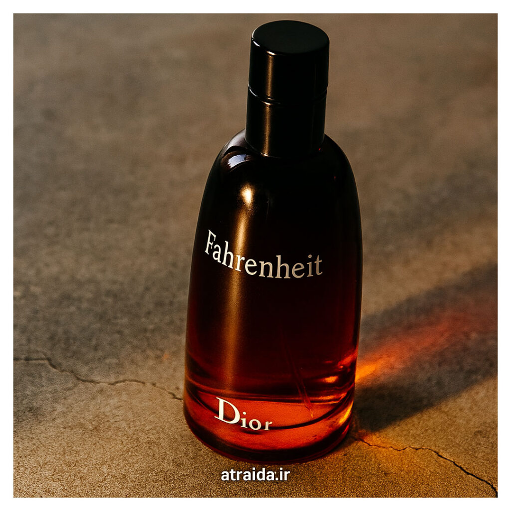 این تصویر نمایی طبیعی و باکیفیت از شیشه ادکلن فارنهایت Dior رو نشون می‌ده. رنگ گرادیانی قرمز تا نارنجی بطری، حس گرما و قدرت رایحه رو منتقل می‌کنه. در پایین برچسب atraida.ir عطر آیدا ( امیر عطری) نوشته شده