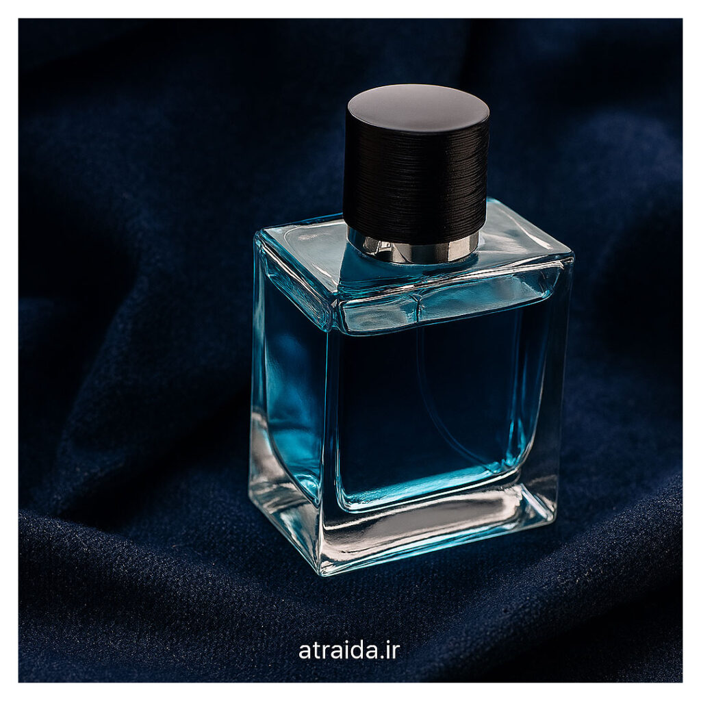 تصویر "عطر خنک مردانه با ماندگاری بالا " طراحی شفاف و رنگ آبی خنک روی پارچه‌ای مخملی که حس طراوت، خنکی و لوکس بودن را القا می‌کند. برچسب «atraida.ir» هویت برند عطر آیدا (امیر عطری ) درج شده است